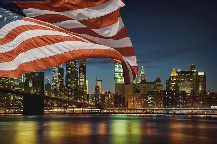 Flagge der vereinigten staaten new yorks brooklyn bridge und die skyline von manhattan beleuchtet