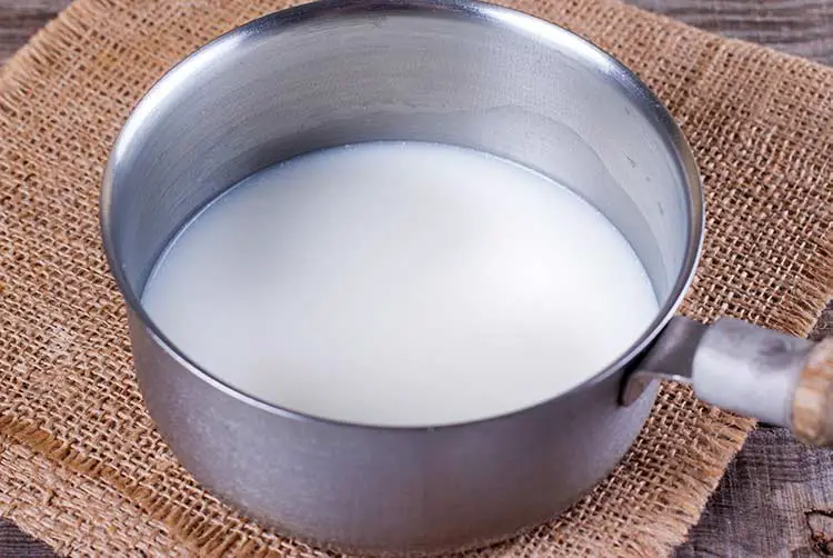 Milch in einem topf auf einem holztisch
