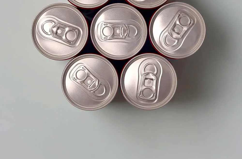 Viele neue aluminiumdosen von soda-softdrink-, limonade-cola-, bier- oder energy-drink-behältern. getränkeherstellungskonzept und massenproduktion