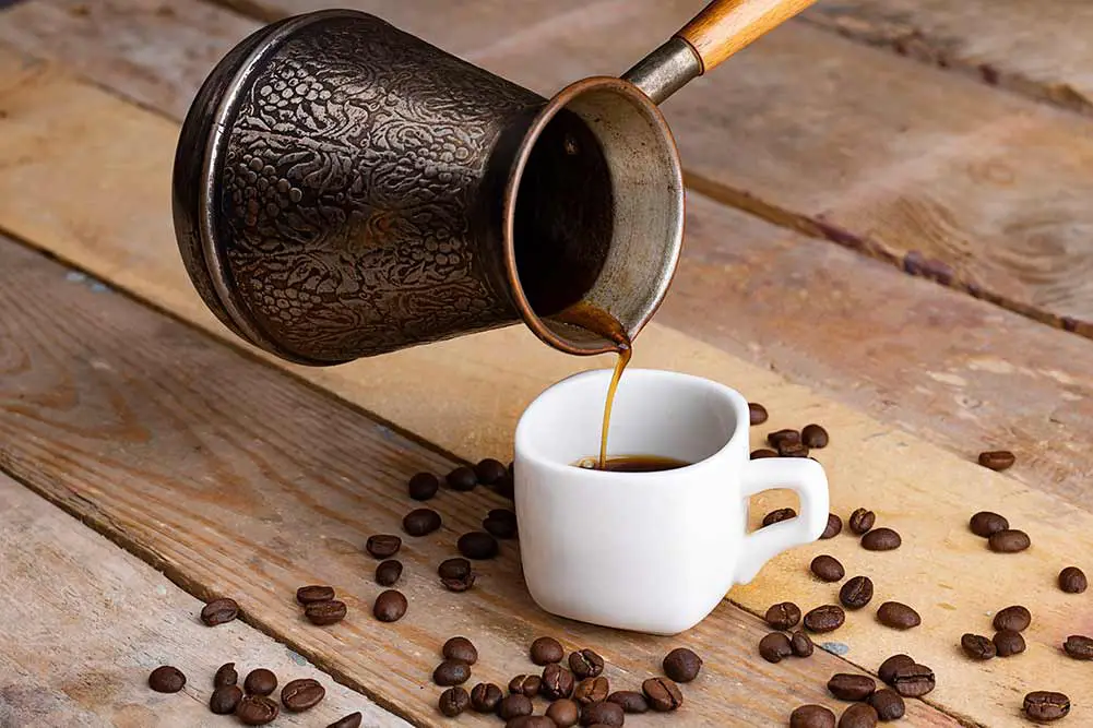 Metal turk und kaffeebohnen auf einem hölzernen hintergrund