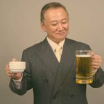 Porträt eines reifen asiatischen geschäftsmannes mit einem glas bier