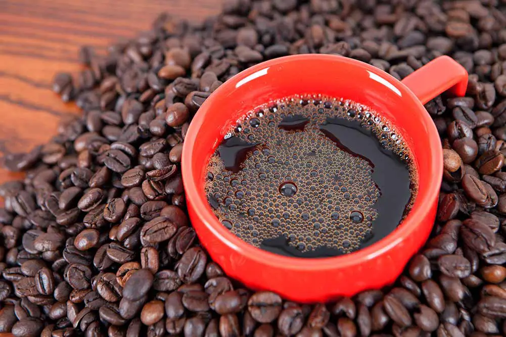 Kaffee diente in einer schale mit kaffeebohnen als hintergrund