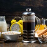 Frisch gebrühter kaffee und eine auswahl an frühstücksspeisen auf holztisch, nahaufnahme