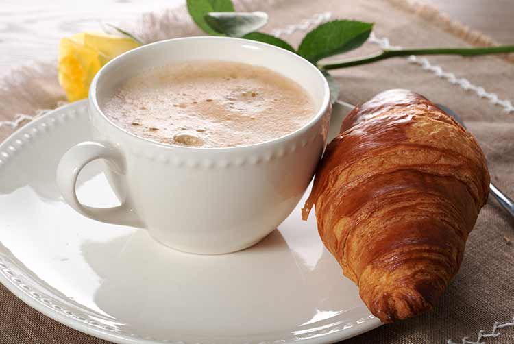 Ein europäischer frühstückskaffee mit milch und croissants