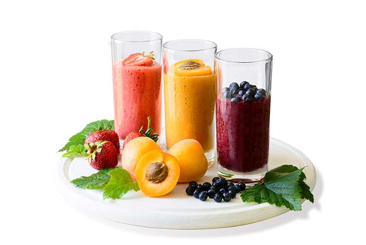 Isolierte erdbeer-, blaubeer- und aprikosen-smoothies. detox- und gesundes ernährungskonzept