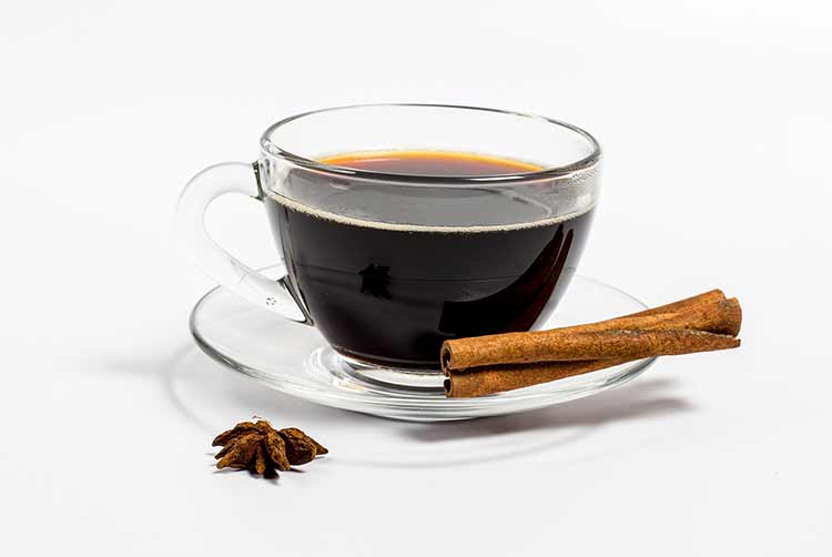 Aromatischer, leckerer kaffee in einer glasschale und zimt