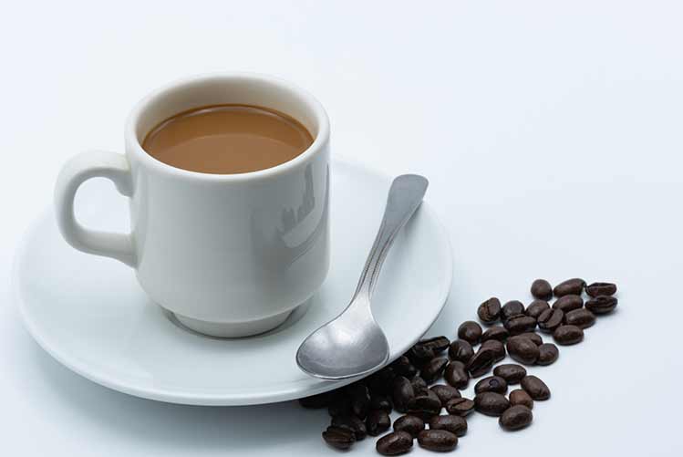Milchkaffee in einer keramiktasse auf weißem hintergrund