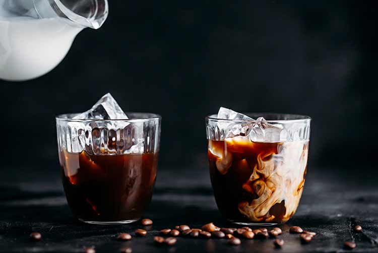 Kaffee mit eis in einem glas, milch in ein glas gegossen.