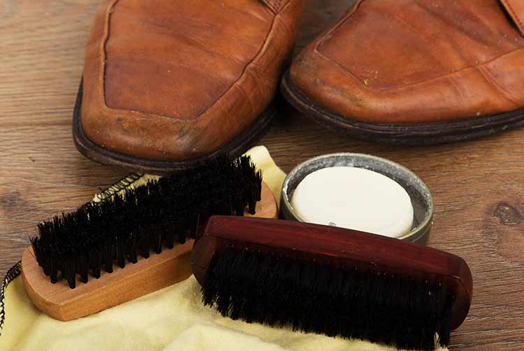 Schuhe und reinigungsgeräte auf einem rustikalen holzboden