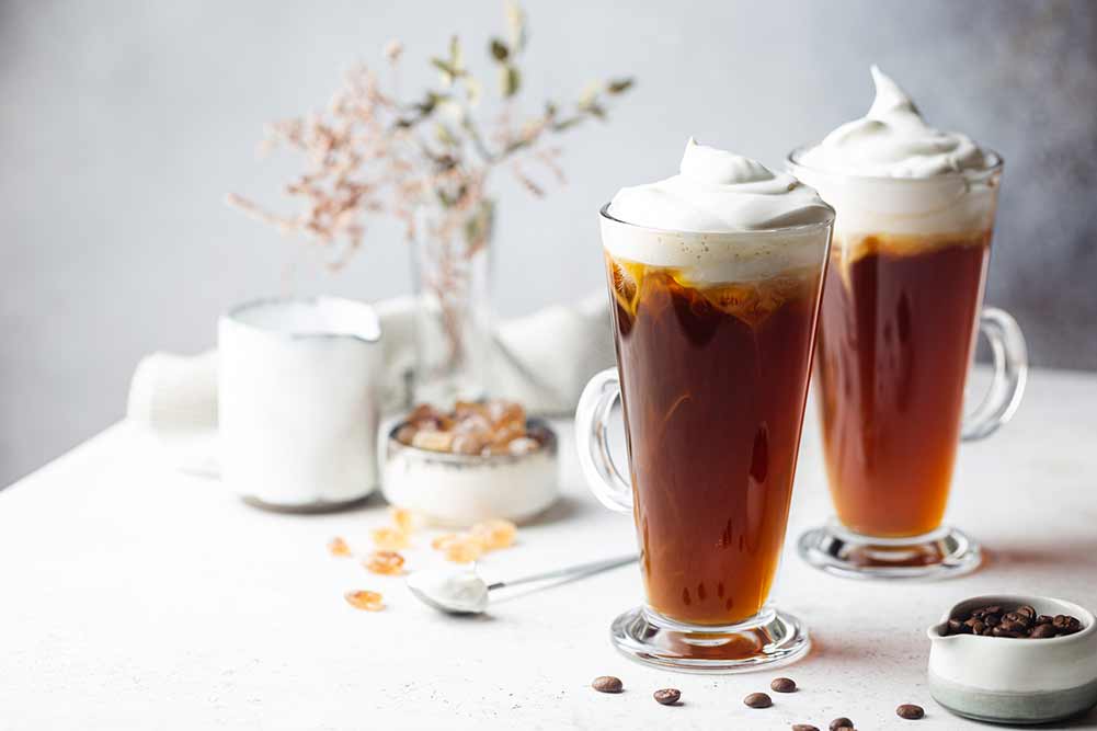 Eiskaffee in einem hohen glas mit sahne übergossen