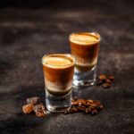 Kaffeecocktail mit schnaps in schnapsgläsern auf dunklem vintage-hintergrund
