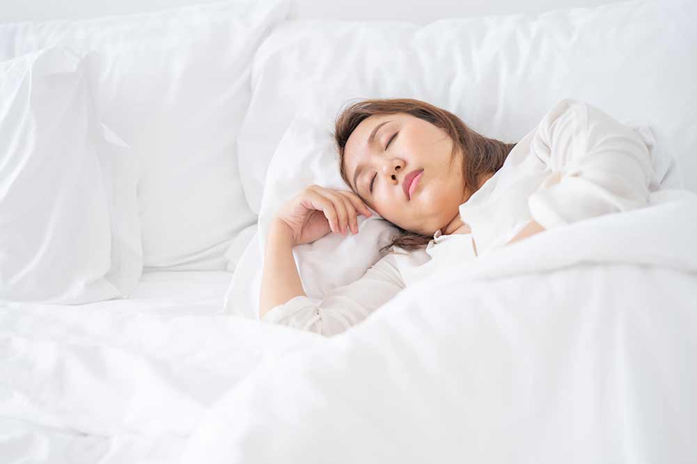 Asiatische schönheit schlafen tief im bett im schlafzimmer zum entspannen hygienischer schlaf, entspannungskonzepte, körperverjüngung