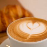Hintergrundbild von cappuccino mit croissant an der seite