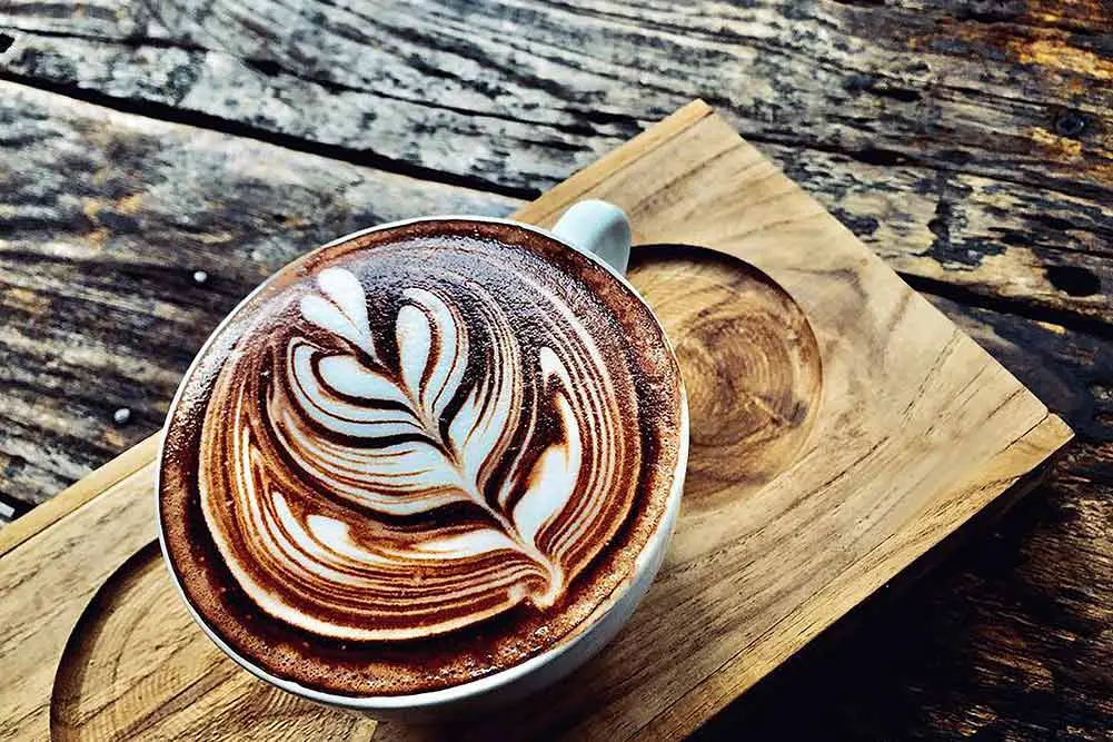 Tasse kaffee latte auf dunklem holztisch, schöne latte art
