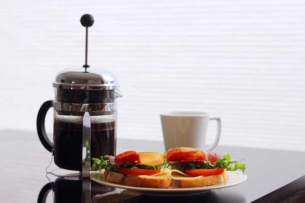 Gesundes frühstück mit sandwiches und kaffee in französisch presse, skandinavischer stil