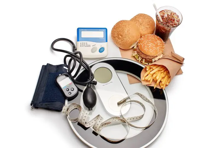 Fast food und medizinische geräte tonometer (blutdruckmessgerät) und blutzuckermessgerät, waage und maßband auf weißem hintergrund. konzept der ungesunden ernährung und gesundheit.