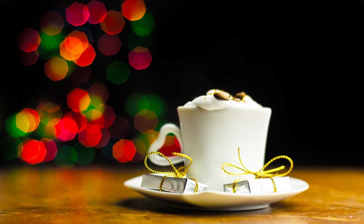 Weihnachtskaffee mit schlagsahne und einem kleinen geschenk auf den hintergrund-bokeh-lichtern, weihnachten