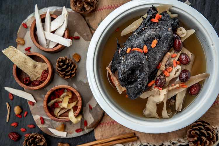 Chinesischer traditioneller nahrhafter gesundheitseintopf, geschmortes hähnchen mit schwarzem knochen, chinesische schwarze hühnersuppe. diese suppe ist unter chinesischem essen und asiatischem essen als gesunde suppe, essen als medizin sehr berühmt. ansicht von oben.