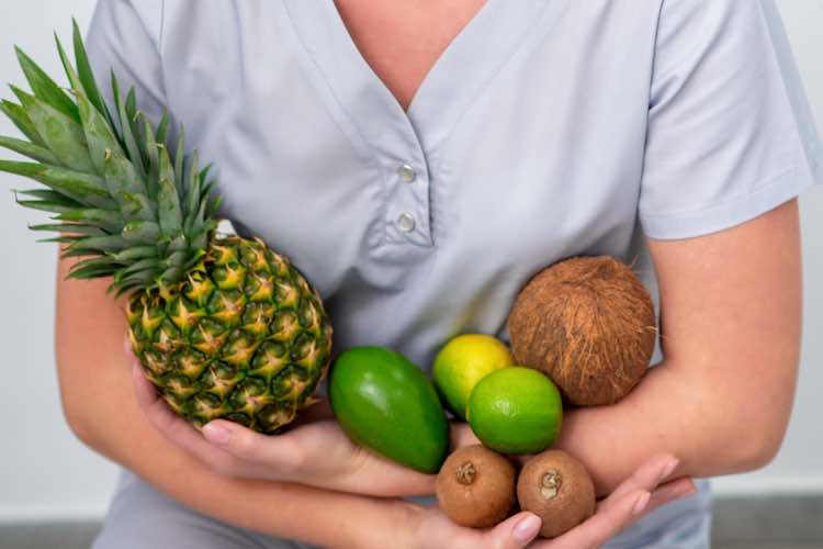 Verschiedene köstliche tropische früchte auf weiblichen armen hautnah.