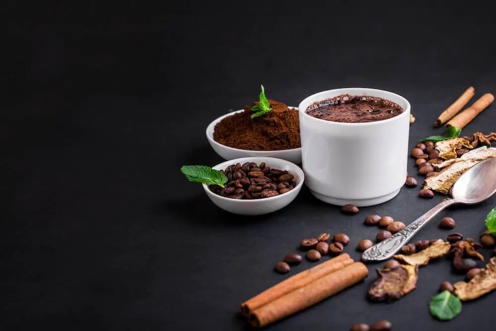 Mushroom chaga coffee superfood trend-trockene und frische pilze und kaffeebohnen auf dunklem hintergrund mit minze. kaffeepause