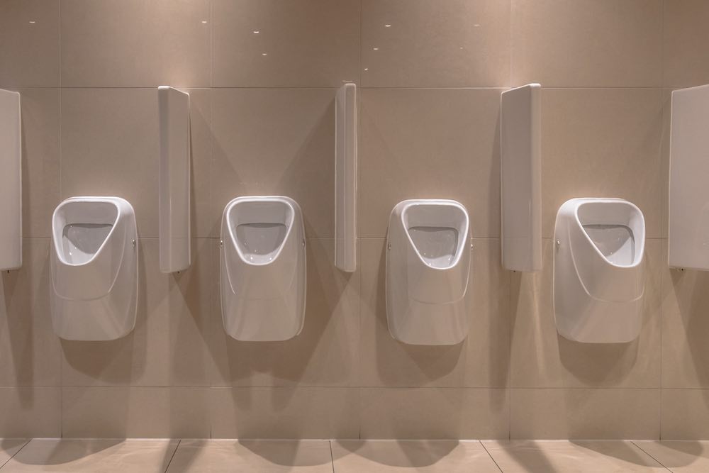 Reihe moderner urinale im neuen badezimmer des theaters