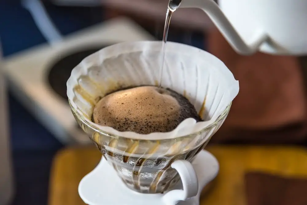 Nahaufnahme von filterkaffeemaschine, wasserkocher mit thermometer und digitalwaage auf holztisch. barista brüht kaffee, methode gießt über, tropft kaffee